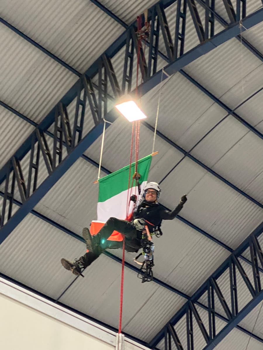 Técnico em acesso por cordas instalando a bandeira da Irlanda